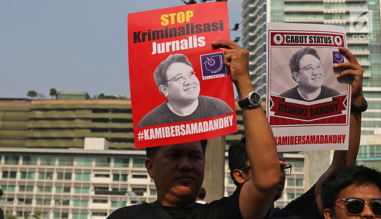 Jurnalis yang tergabung dalam Aliansi Jurnalis Independen (AJI) menunjukkan poster saat menggelar aksi pada Car Free Day di Bundaran HI, Jakarta, Minggu (29/9/2019). Polisi menjeratnya dengan UU ITE atas cuitan Dandhy soal isu Papua. (Liputan6.com/Herman Zakharia)
