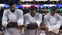 Para pemain Boston Celtics,  Amir Johnson, Jae Crowder, Gerald Green berpegangan tangan saat lagu kebangsaan dikumandangkan sebelum melawan Brooklyn Nets pada laga NBA preseason basketball game, Boston, Selasa (18/10/2016) WIB. (AP/Charles Krupa)