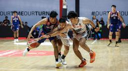 Pemain Satria Muda, Widyanta Putra Teja (tengah) dan Julian Alexandre Chalias (kanan) berusaha merebut bola dari pemain Pelita Jaya, Yesaya Alessandro Saudale pada laga gim ketiga final IBL All Indonesia 2024 yang berlangsung di Hall Basket, Senayan, Jakarta, Sabtu (06/10/2024). Pelita Jaya menang dengan skor 75-70. (Bola.com/Bagaskara Lazuardi)