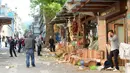 Orang-orang berdiri di depan sebuah toko yang rusak akibat ledakan di Bursa, bagian barat Turki, Rabu (27/4). Sedikitnya 10 orang terluka dalam ledakan yang berasal dari aksi bom bunuh diri yang dilakukan seorang wanita. (Onur YURTSEVER/AFP)