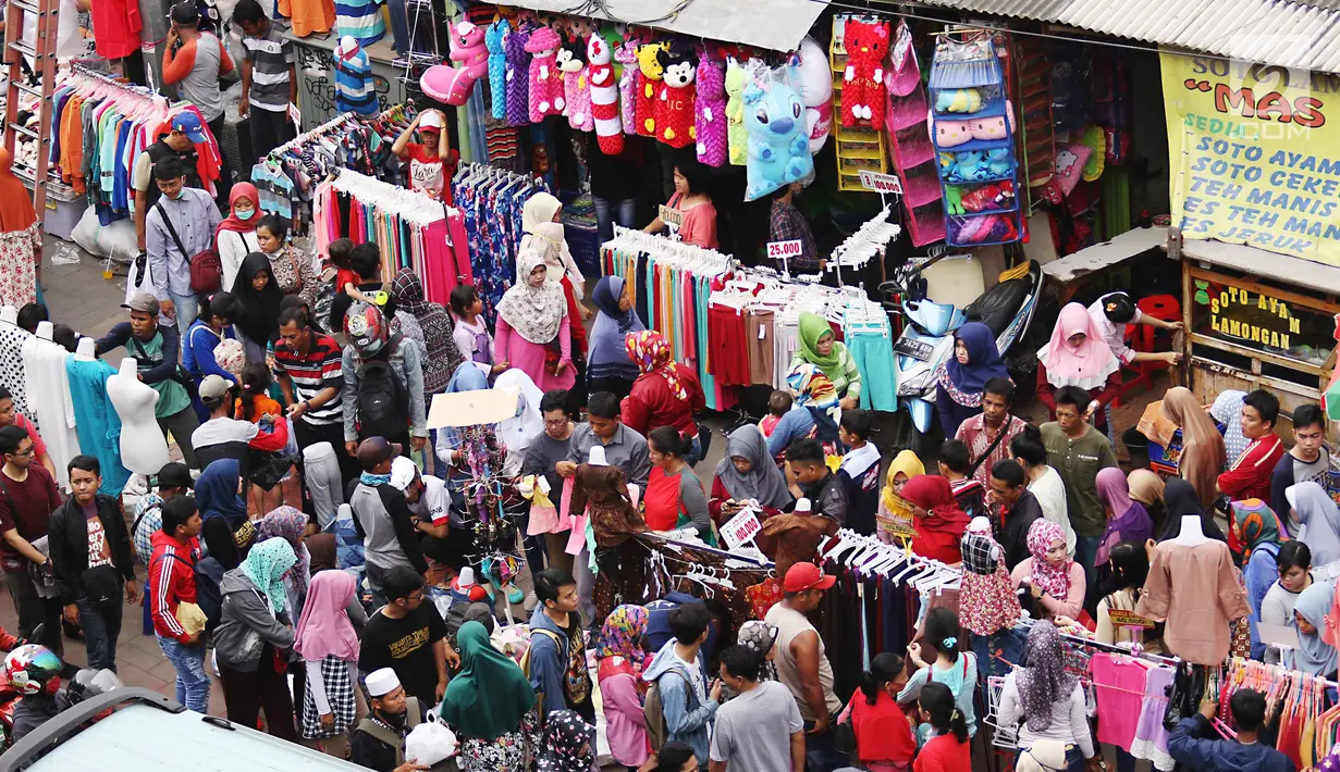 Sejumlah pengunjung melihat pakaian yang dijual di pasar Tanah Abang di Jakarta, Minggu (11/6). Para pengunjung pasara Tanah Abang ini tak hanya datang dari Jakarta, tapi juga datang dari daerah lain di luar Jakarta. (Liputan6.com/Angga Yuniar) 