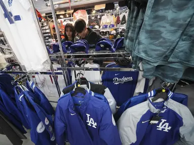 Para pelanggan berbelanja barang-barang yang berkaitan dengan Shohei Ohtani dari Los Angeles Dodgers di sebuah toko perlengkapan olahraga, "SELECTION," di distrik Shinjuku, Tokyo, Rabu, 13 Desember 2023. (AP Photo/Eugene Hoshiko)