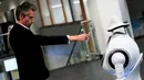 Seorang karyawan perusahaan Belgia, ZoraBots, memperlihatkan kode QR selama pengujian robot yang disebut CRUZR di Antwerp University Hospital (UZA) pada 29 Mei 2020. Robot ini dapat mendeteksi demam serta mengetahui pengunjung rumah sakit  yang memakai Masker atau tidak. (Kenzo TRIBOUILLARD/AFP)