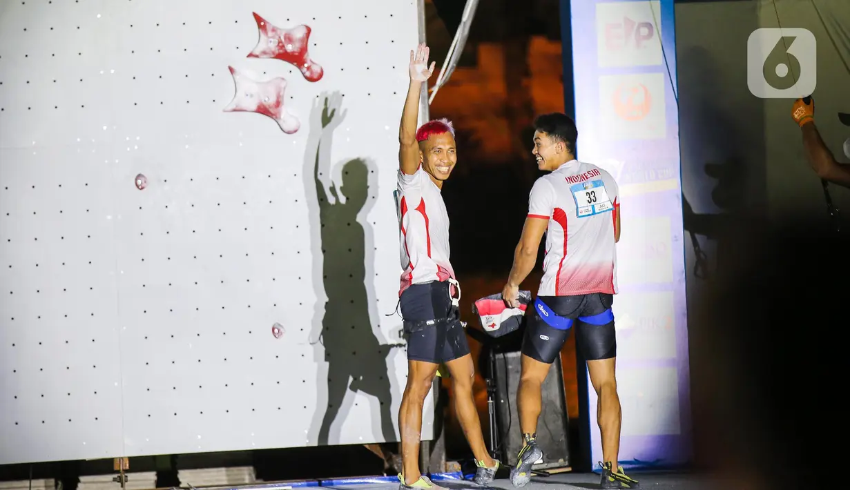 Atlet panjat tebing Indonesia Aspar Jailolo (kiri) menyapa pendukungnya saat meraih juara kategori speed dalam Kejuaran Dunia Panjat Tebing 2022 (International Federation of Sport Climbing/IFSC) di Jakarta, Sabtu (24/9/2022). Aspar berhasil mengalahkan lawan yang juga kompatriotnya, Kiromal Katibin. Catatan waktu Aspar adalah 5,39 detik. (Liputan6.com/Faizal Fanani)
