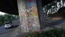 Pengendara mobil melintasi sisi tiang penyangga Jalan Tol Pelabuhan Lingkar Dalam Jakarta di Jalan Ancol Timur, Jakarta, Selasa (16/6/2020). Seni mural yang dulu menghiasi tiang-tiang jalan tol di kawasan tersebut kini terlihat kusam dan berdebu. (Liputan6.com/Helmi Fithriansyah)