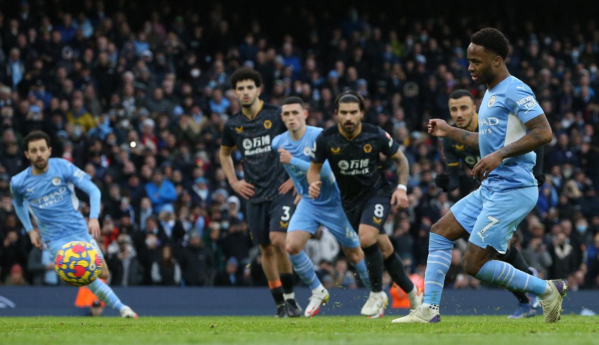Gelandang Manchester City, Raheem Sterling melakukan eksekusi penalti ke gawang Wolverhampton Wanderers pada laga Liga Inggris 2021/2022 di Ettihad Stadium, Manchester, 11 Desember 2021. Raheem Sterling yang sejak awal musim 2022/2023 berseragam Chelsea mencetak gol ke-100 di Liga Inggris saat menyumbang satu-satunya gol kemenangan Manchester City atas Wolverhampton Wanderers lewat eksekusi penalti pada pekan ke-16 Liga Inggris 2021/2022 (11/12/2021). (AFP/Nigel Roddis)
