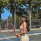 Dalam foto ini, Anya Geraldine tampil santai dengan sport bra berwarna lilac. Anya melengkapi penampilannya itu dengan topi berwarna gelap. Rambut panjang bergelombangnya dibiarkan terurai begitu saja. Sambil memegang raket tenis, Anya berpose cantik di samping net lapangan. Dia memperlihatkan ekspresi polos melihat ke belakang. (Instagram/anyageraldine)