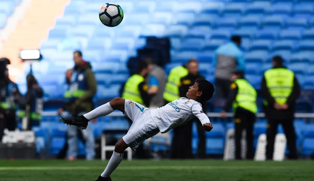 Aksi Cristiano Ronaldo Jr saat melakukan tendangan salto usai pertandingan antara Real Madrid dan Atletico Madrid di Madrid (8/4). Sebelumnya, Cristiano Ronaldo menciptakan satu gol ke gawang Juventus lewat tendangan salto. (AFP Photo/Gabriel Bouys)