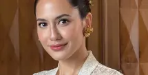 Pevita Pearce tampil memesona mengenakan atasan kebaya brokat putih lengan panjang sebagai inner dipadukan buister warna biru yang dihiasi bros besar serasi dengan anting-anting dan hiasan rambutnya. [ @pevpearce]