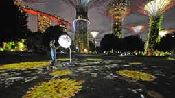 Pengunjung berinteraksi dengan instalasi multimedia "Dandelion" di Gardens by the Bay, Singapura, pada 9 November 2020. "Dandelion" memungkinkan orang-orang di Singapura dan Jepang berinteraksi satu sama lain yang dipamerkan secara bersamaan di kedua negara hingga 15 November. (Xinhua/Then Chih Wey)