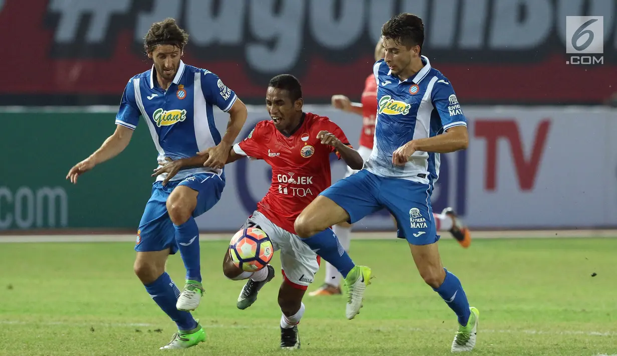 Pemain depan Persija, Pandi Lestaluhu (tengah) berusaha lolos dari kawalan dua pemain RCD Espanyol di laga persahabatan di Stadion Patriot Candrabhaga, Bekasi, Rabu (19/7). Persija kalah telak dari RCD Espanyol 0-7. (Liputan6.com/Helmi Fithriansyah) 