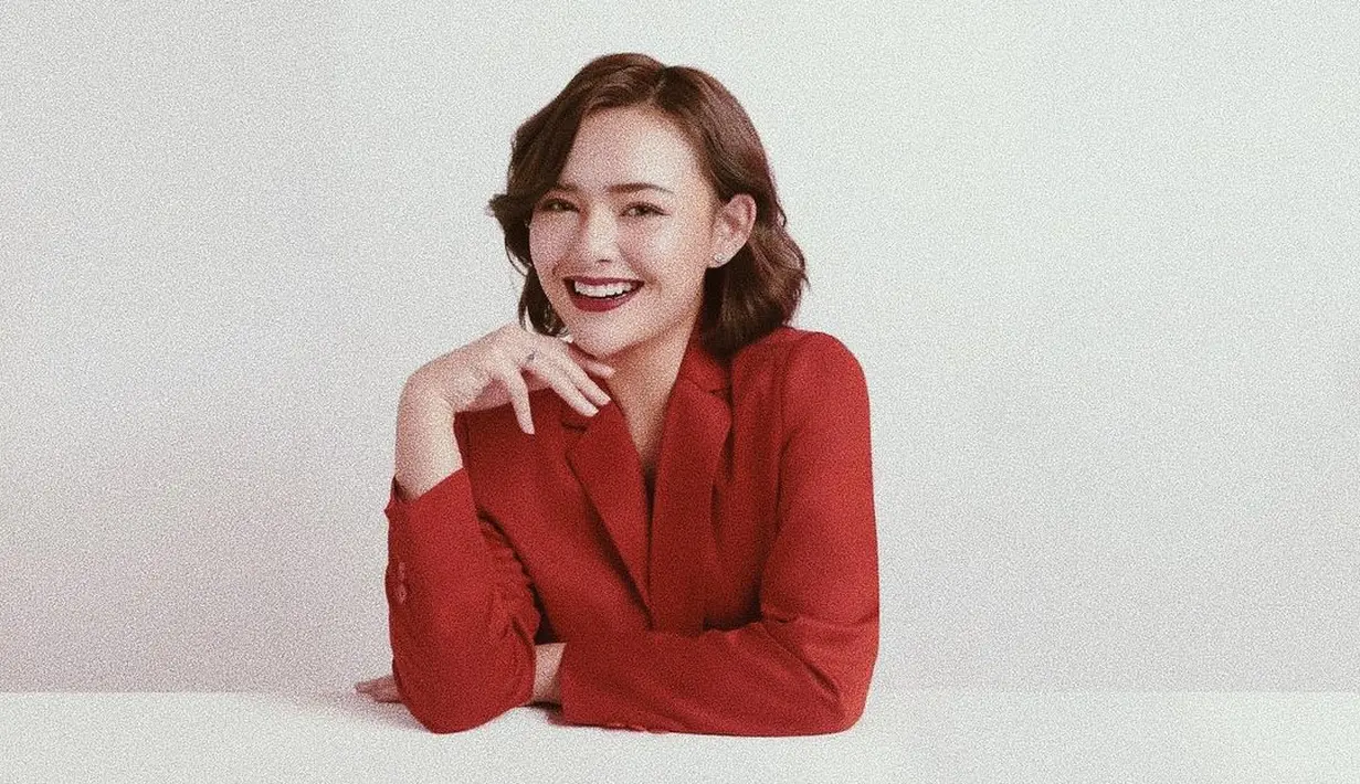 Tampilan perempuan modern dengan blazer merah dan bibir berwarna senada yang bold. (IG: @amandamanopo)