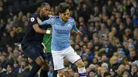 Gelandang Manchester City, David Silva, berebut bola dengan pemain Everton, Djibril Sidibe, pada laga Premier League di Stadion Etihad, Rabu (1/1/2020). Manchester City menang 2-1 atas Everton. (AP/Rui Vieira)