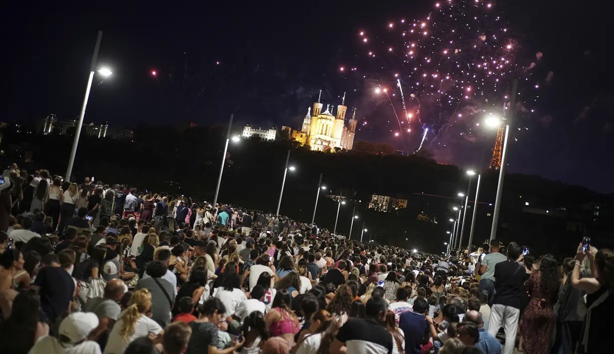 Orang-orang berkumpul di jembatan untuk menyaksikan kembang api Hari Bastille di Lyon, Prancis tengah, Jumat, 14 Juli 2023. (AP Photo/Laurent Cipriani)