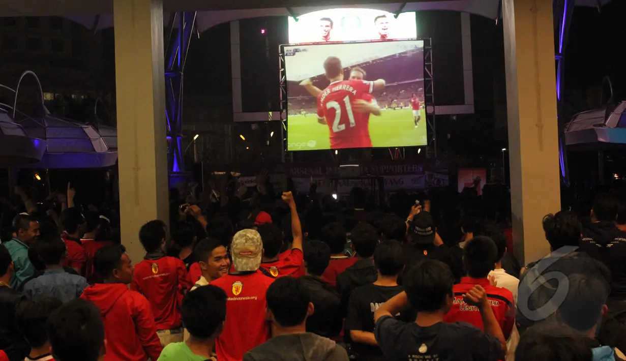 Pendukung Manchester United bersorak gembira saat tim kesayangan mereka berhasil menjebol gawang lawan saat nonton bola seru Manchester United vs Arsenal di Karawang Central Plaza, Minggu (17/5/2015). (Liputan6.com/Helmi Afandi)