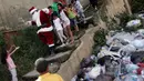 Seorang anak perempuan meminta untuk di peluk Santa Claus di kawasan kumuh Petare di Caracas, Venezuela (11/12). Kunjungan Santa Claus ini untuk menghibur anak-anak dalam menyambut datangnya natal. (Reuters/Ueslei Marcelino)