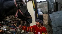 Seorang anak Palestina terlihat di area permukiman kumuh sebuah kamp pengungsi saat cuaca badai di Kota Khan Younis, Jalur Gaza selatan, pada 26 November 2020. (Xinhua/Yasser Qudih)