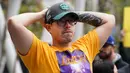Fans LA Lakers tampak sedih usai Kobe Bryant meninggal dunia di Staples Center, Minggu (26/1/2020). Legenda basket NBA itu wafat dalam kecelakaan helikopter di Calabasas, California. (AFP/Rachel Luna)