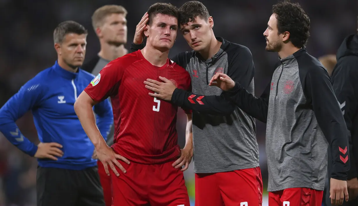 Pemain Denmark Andreas Christensen dan Joakim Maehle menangis usai pertandingan melawan Inggris pada semifinal Euro 2020 di stadion Wembley di London, Kamis (8/7/2021). Inggris akan bertemu Italia di babak final. (Laurence Griffiths/Pool Photo via AP)