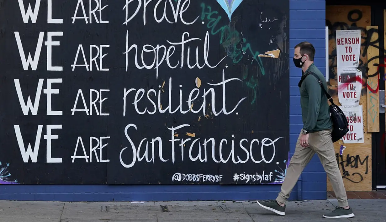 Seorang pria yang mengenakan masker berjalan melewati graviti saat wabah COVID-19 di San Francisco, California, Amerika Serikat, Kamis (12/11/2020). California menjadi negara bagian kedua selain Texas yang mencatat 1 juta kasus infeksi COVID-19. (AP Photo/Jeff Chiu)