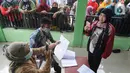 Petugas PT Pos Indonesia memotret wajah penerima Bantuan Sosial Tunai (BST) bulan Januari di halaman Masjid Jami Al-Hidayah RW 01 Bedahan, Depok, Selasa (16/2/2021). Sekitar 159.470 Keluarga Penerima Manfaat (KPM) di Kota Depok menerima BST yang disalurkan pada Februari ini (merdeka.com/Arie Basuki)