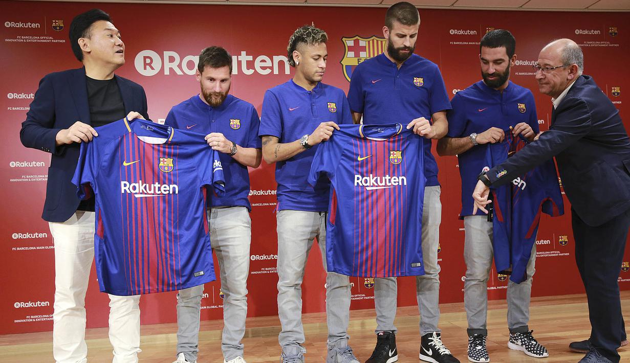 Messi cs bersama Bos Rakuten, Hiroshi Mikitani dan Wakil Presiden FC Barcelona, Manel Arroyo memamerkan jersey baru La Blaugrana di Tokyo, Jepang (13/7).  Barcelona menjadikan Rakuten sebagai sponsor utama musim ini. (AP/Eugene Hoshiko)