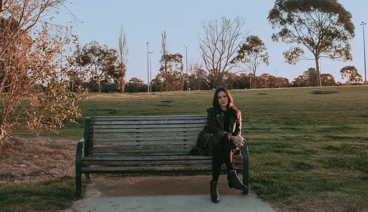 Saat liburan ke Australia, Raisa tampak duduk di sebuah kursi di Albert Park and Lake dengan santainya. Menggunakan busana serba hitam, ia tampak cantik diterpa matahari dengan latar taman dan pepohonan. (Liputan6.com/IG/@raisa6690)