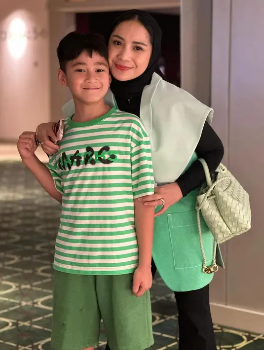 Kian sempurna, dengan aksesori tas Bottega Veneta East-West Andiamo Top handle bag with elongated silhouette in supple Intrecciato leather with signature knot detail and sliding cross-body strap. Tas warna fresh mint ini ditaksir seharga Rp78 jutaan. [@raffinagita1717].