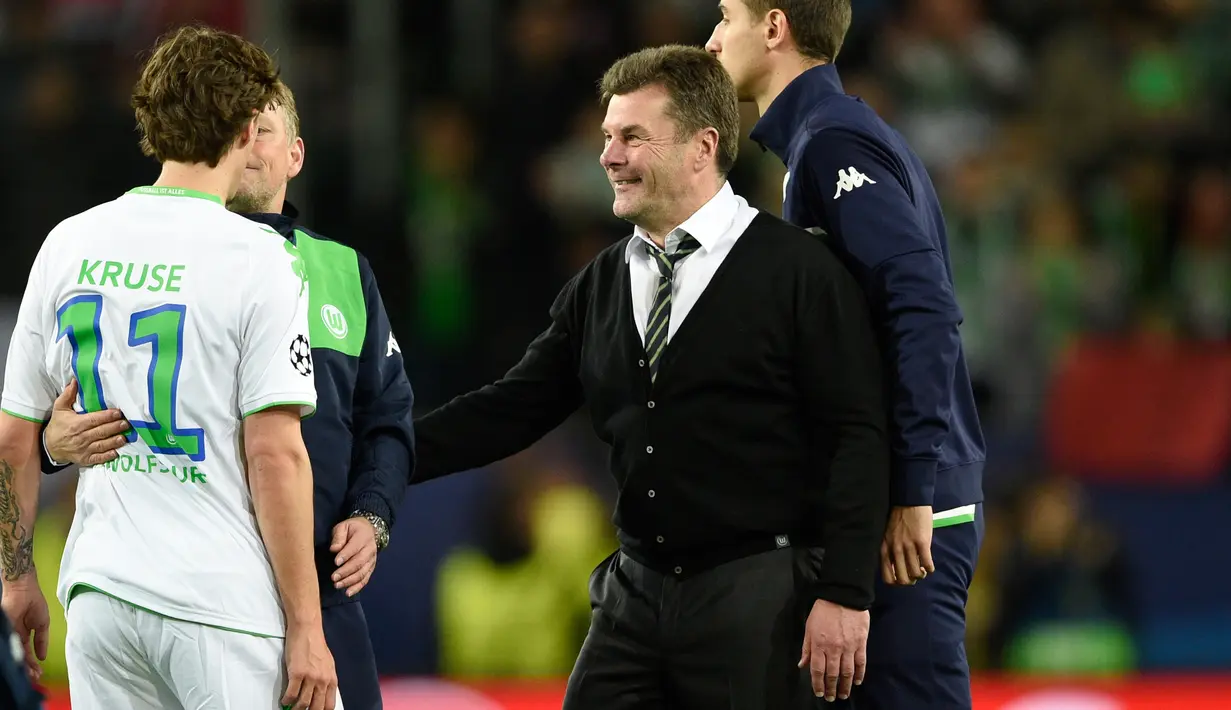 Pelatih Wolfsburg Dieter Hecking merayakan kemenangan dengan Max Kruse setelah pertandingan leg pertama liga champions di Stadion Volkswagen Arena, Wolfsburg, Jerman (7/4). Madrid takluk atas Wolfsburg dengan skor 2-0. (Reuters/Fabian Bimmer)