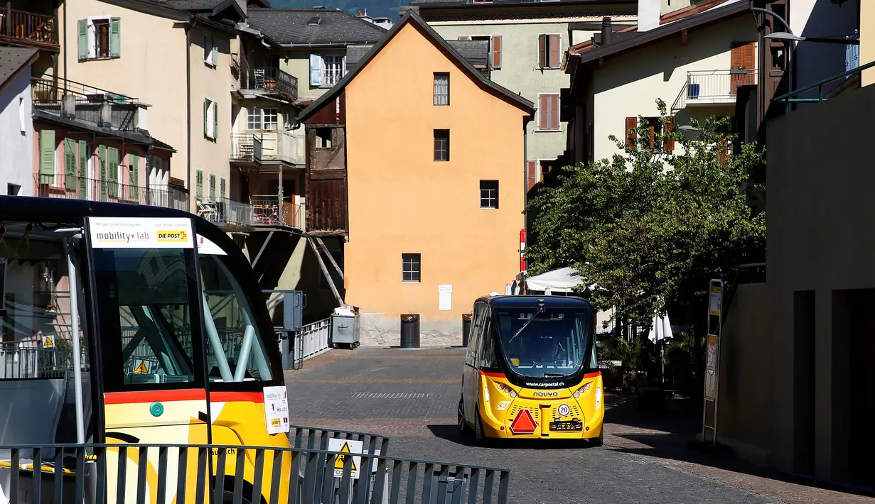 Dua angkutan umum tanpa kemudi dan sopir melintasi jalanan Sion, Swiss, Kamis (23/6). Angkutan umum listrik pertama buatan PostAuto Schweiz ini memiliki 11 kursi penumpang dengan kecepatan maksimal 20 km per jam. (REUTERS/Ruben Sprich)