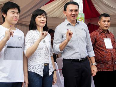 Calon gubernur DKI, Basuki Tjahaja Purnama (Ahok) bersama istri, Veronica Tan dan anaknya Nicholas Sean menunjukkan tinta pada jarinya usai mencoblos pada Pilkada DKI putaran kedua di TPS 54, Pluit, Jakarta Utara, Rabu (19/4). (Liputan6.com/Faizal Fanani)