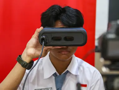 Siswa mengikuti perekaman data identitas retina mata saat perekaman KTP elektronik di SMAN 37 Jakarta, Tebet, Jakarta Selatan, Senin (6/5/2024). (Liputan6.com/Angga Yuniar)