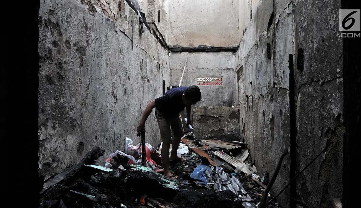 Warga mencari sisa barang di antara puing bangunan rumah yang hangus akibat kebakaran di Tambora, Jakarta, Kamis (10/1). Kebakaran yang melanda kawasan tersebut diduga akibat korsleting listrik. (Merdeka.com/Iqbal Nugroho)