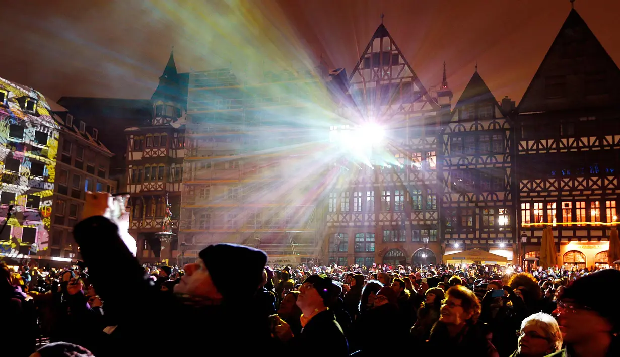 Ratusan warga menyaksikan gedung-gedung disinari cahaya saat pembukaan resmi festival cahaya "Luminale" di Frankfurt, Jerman, (18/3). (AP Photo / Michael Probst)