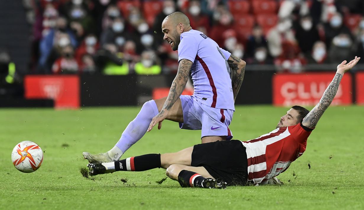 Bek Barcelona, Dani Alves ditekel pemain Athletic Bilbao, Inigo Martinez pada pertandingan babak 16 besar Copa del Rey Cup Spanyol di stadion San Mames di Bilbao, Jumat (21/1/2022). Kemenangan ini mengantar Bilbao melaju ke babak perempat final. (AP Photo/Alvaro Barrientos)