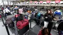 Penumpang maskapai Avianca menunggu penerbangan yang tertunda di Bandara Internasional John F Kennedy (JFK), New York, Senin (8/1). Banjir yang menimpa bandara tersebut menambah kesemrawutan yang terjadi beberapa hari belakangan. (AP/Richard Drew)