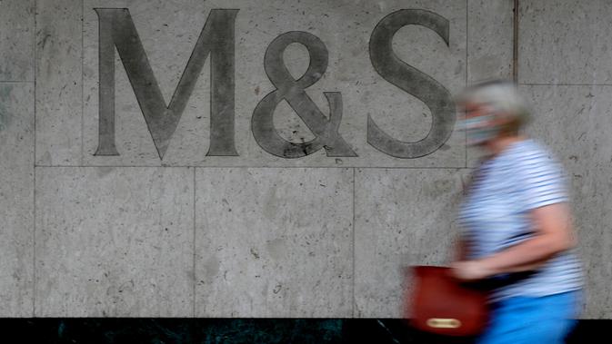 Seorang perempuan melewati tanda di cabang toko Marks and Spencer di London, Selasa (18/8/2020). Peretail Inggris, Marks & Spencer pada Selasa (18/8) mengumumkan rencananya untuk memangkas 7.000 pekerja dalam tiga bulan ke depan di tengah pandemi COVID-19. (AP Photo/Kirsty Wigglesworth)