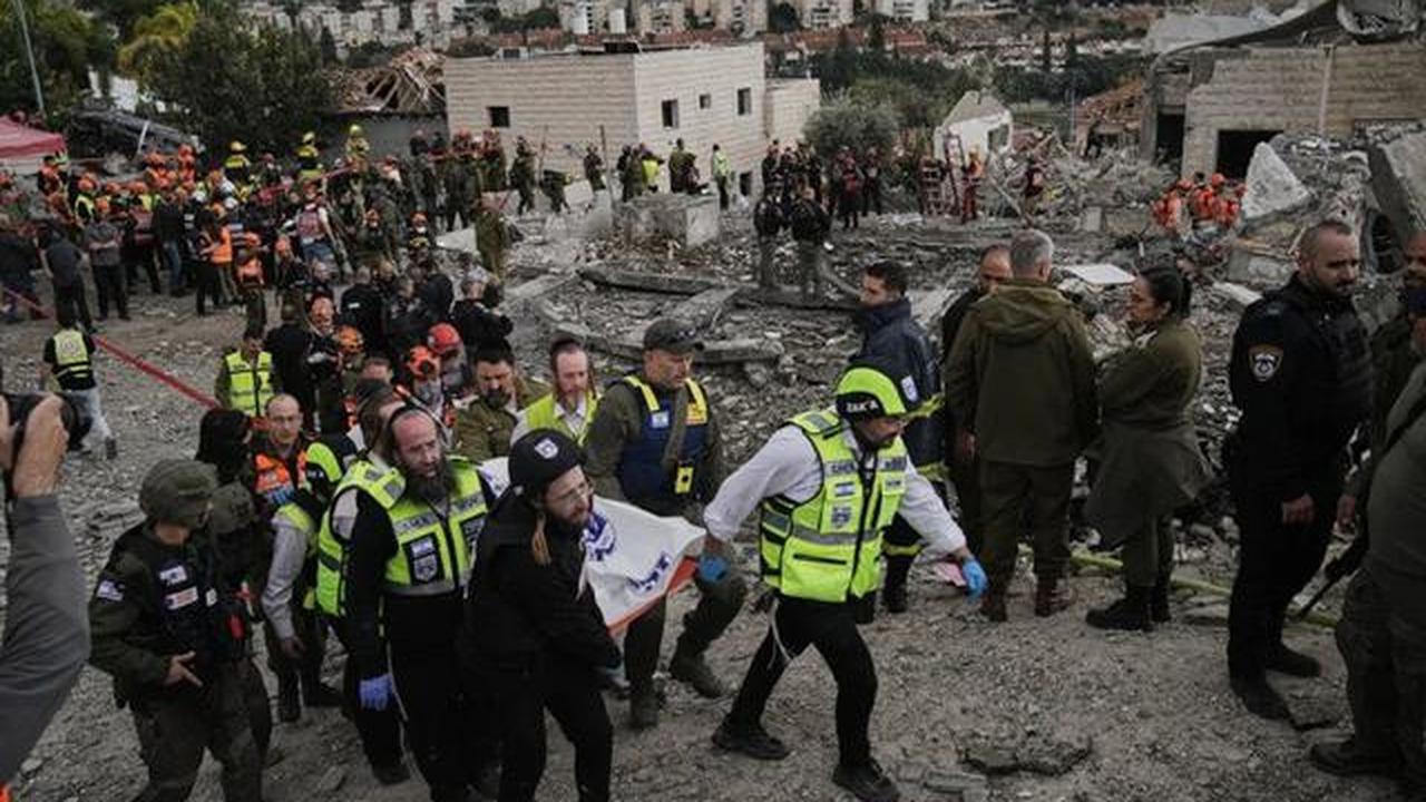 Petugas penyelamat dan personel militer mengangkat jenazah korban di lokasi serangan rudal Iran di Beit Shemesh, Israel, Minggu (1/3/2026), setelah beberapa orang tewas akibat serangan tersebut. (Dok. AP/Leo Correa)