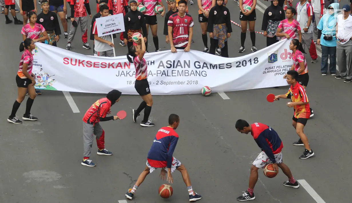 Para atlet yang mendukung penyelenggaraan Asian Games memeriahkan parade di Jalan MH Thamrin, Jakarta, Minggu (15/5). Total ada 42 rombongan dari berbagai komunitas, serta BUMN dan BUMS. (Liputan6.com/Arya Manggala)