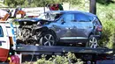 Sebuah truk derek mengangkut mobil pegolf terkenal Tiger Woods setelah kecelakaan di Rancho Palos Verdes, California, pinggiran Los Angeles, Selasa (23/2/2021). SUV itu mengalami kerusakan parah di bagian depannya dan dikelilingi serpihan dari bagian kendaraan. (Frederic J. BROWN / AFP)