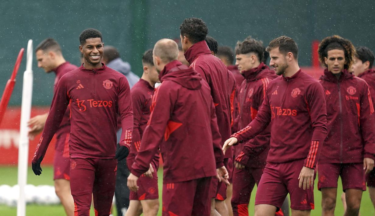 Senyum dari penyerang MU, Marcus Rashford (kiri), saat hadir untuk menjalani sesi latihan di Carrington Training Ground, Manchester, Inggris, Selasa (19/9/2023). (AP/PA/Martin Rickett)