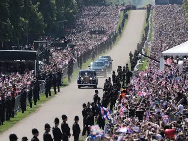 Iring-iringan mobil Meghan Markle saat akan menghadiri prosesi pernikahannya dengan Pangeran Harry di Kastil Windsor, Inggris, Sabtu (195). Warga Inggris bersuka cita menyambut pernikahan Pangeran Harry dengan Meghan Markle. (AP Photo/Emilio Morenatti)