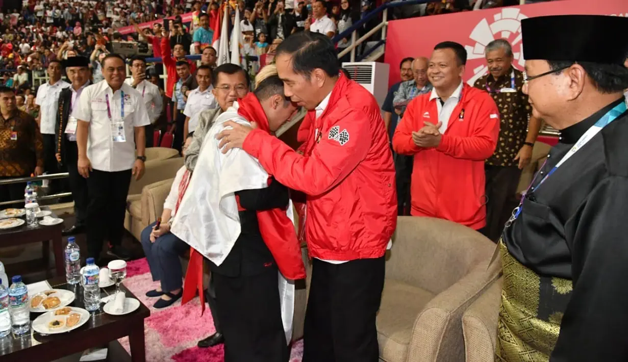 Presiden Joko Widodo atau Jokowi menyalami atlet pencak silat peraih emas Asian Games 2018 Hanifan Yudani disaksikan Ketua Umum Pengurus Besar Ikatan Pencak Silat Indonesia (IPSI) Prabowo Subianto, Jakarta, Rabu (29/8). (Liputan6.com/HO/Biro Pers Setpres)