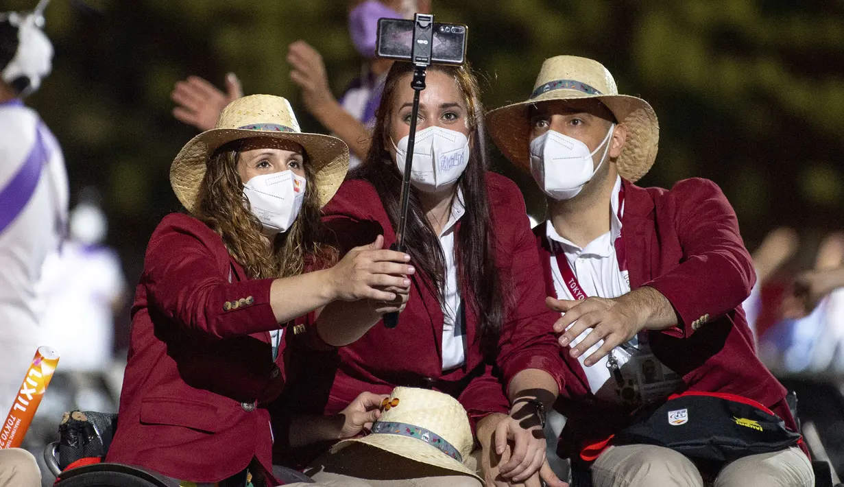 Anggota tim Paralimpiade Spanyol berhenti untuk selfie selama parade atlet pada upacara pembukaan Paralimpiade Tokyo 2020 di Tokyo, Jepang, Selasa, 24 Agustus 2021. (OIS via AP/Joel Marklund)