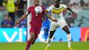 Gelandang Qatar, Abdulaziz Hatem berebut bola dengan penyerang Senegal, Boulaye Dia selama pertandingan grup A Piala Dunia 2022 di Stadion Al Thumama di Doha, Qatar, Jumat (25/11/2022). Berkat kemenangan 3-1, Senegal menjaga harapan lolos ke babak 16 besar. (AP Photo/Petr Josek)