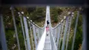 Wisatawan berjalan di atas jembatan gantung yang baru diresmikan di Kota Zermatt, Swiss, 29 Juli 2017. Jembatan baru ini disebut memiliki berat sekitar delapan ton, dan dilengkapi dengan sistem untuk mencegah goyangan. (Valentin Flauraud/Keystone via AP)