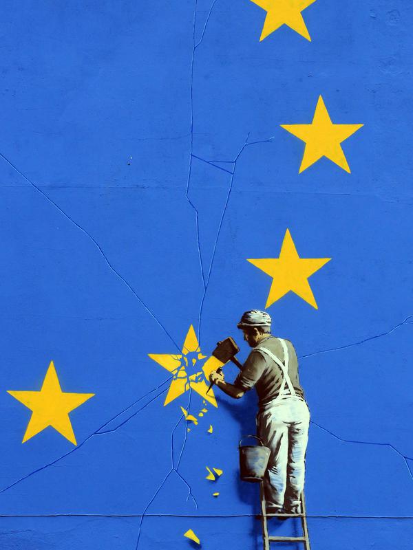 Mural pria tengah menghancurkan salah satu dari 12 bintang kuning bendera Uni Eropa di dinding kawasan Dover, Inggris, Senin (8/5). Bintang-bintang kuning itu merupakan simbol kesatuan, solidaritas, dan harmoni di antara warga Eropa (Gareth Fuller/via AP)