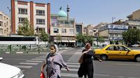 PeRempuan Iran menyeberang jalan di pusat kota Teheran ketika pihak berwenang memperketat pembatasan, Selasa (20/7/2021). Iran memberlakukan lockdown di Teheran dan provinsi terdekat setelah kasus infeksi Covid-19 mencapai rekor tertingginya selama wabah kelima. (ATTA KENARE/AFP)