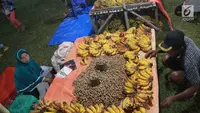 Pedagang menjual pisang dan kacang di pasar malam pada tradisi Malam Qunut di Desa Payunga, Kec. Batudaa, Kab. Gorontalo, Senin (20/5/2019). Tradisi Malam Qunut di Gorontalo dilakukan pada setiap pertengahan bulan Ramadan dengan beramai-ramai memakan pisang dan kacang. (Liputan6.com/Arfandi Ibrahim)