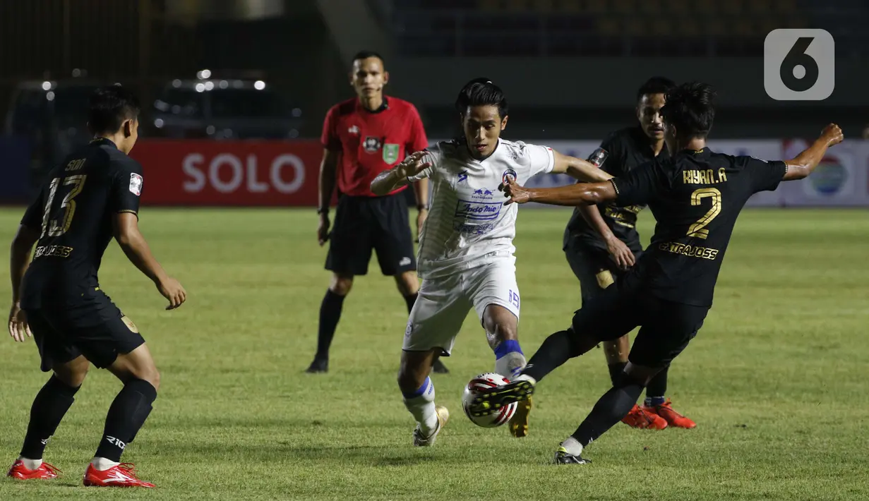 Pemain PSIS Semarang Riyan Ardiansyah (kanan) berebut bola dengan pemain Arema FC Hanif Abdurrauf Sjahbandi dalam pertandingan babak penyisihan Grup A Piala Menpora 2021 di Stadion Manahan, Solo, Selasa (30/3/2021). Arema FC kalah 2-3. (Bola.com/Ikhwan Yanuar)